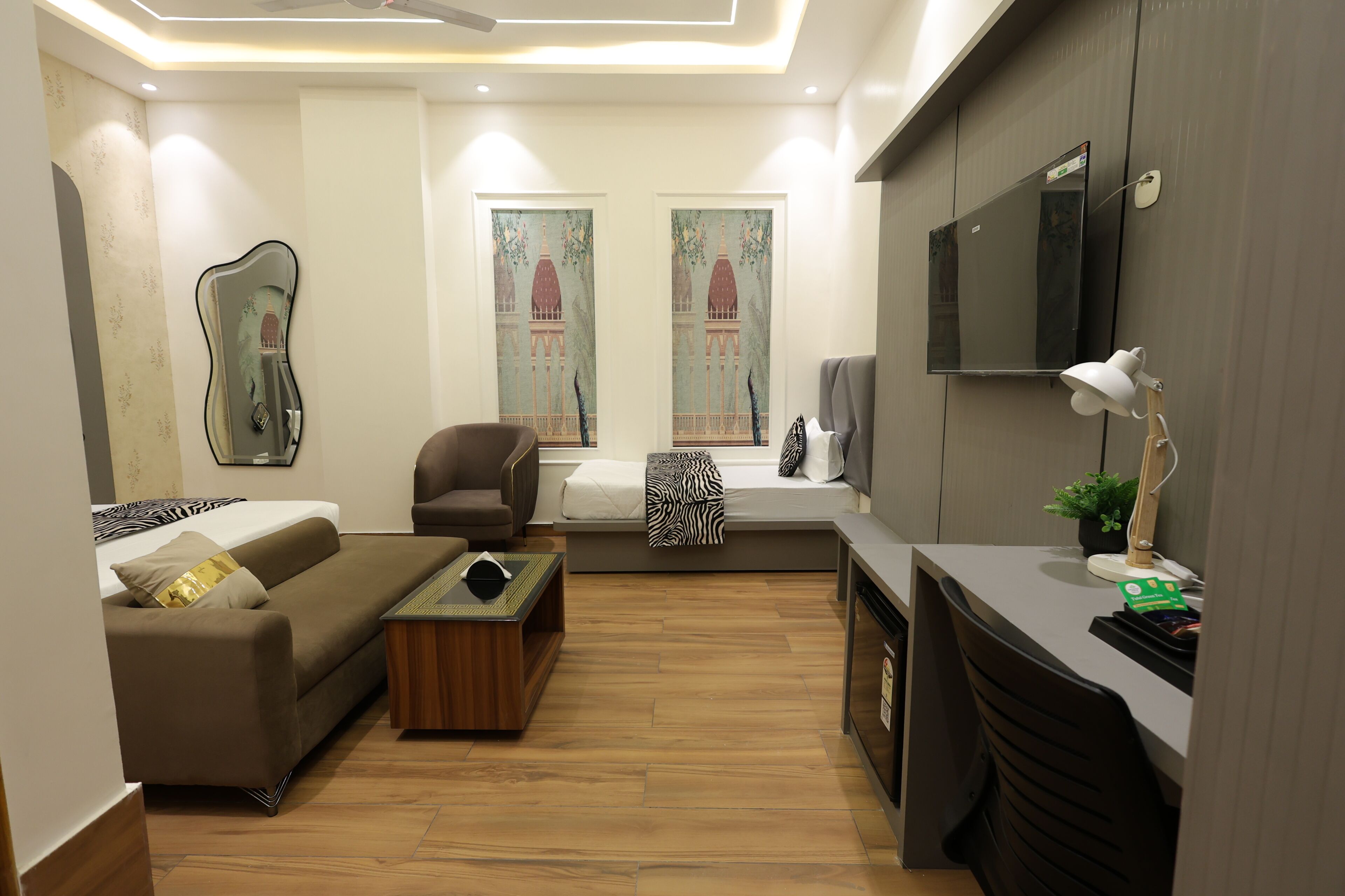 Una sala de estar moderna con un sofá, un sillón, una mesa de centro y un televisor montado en la pared.