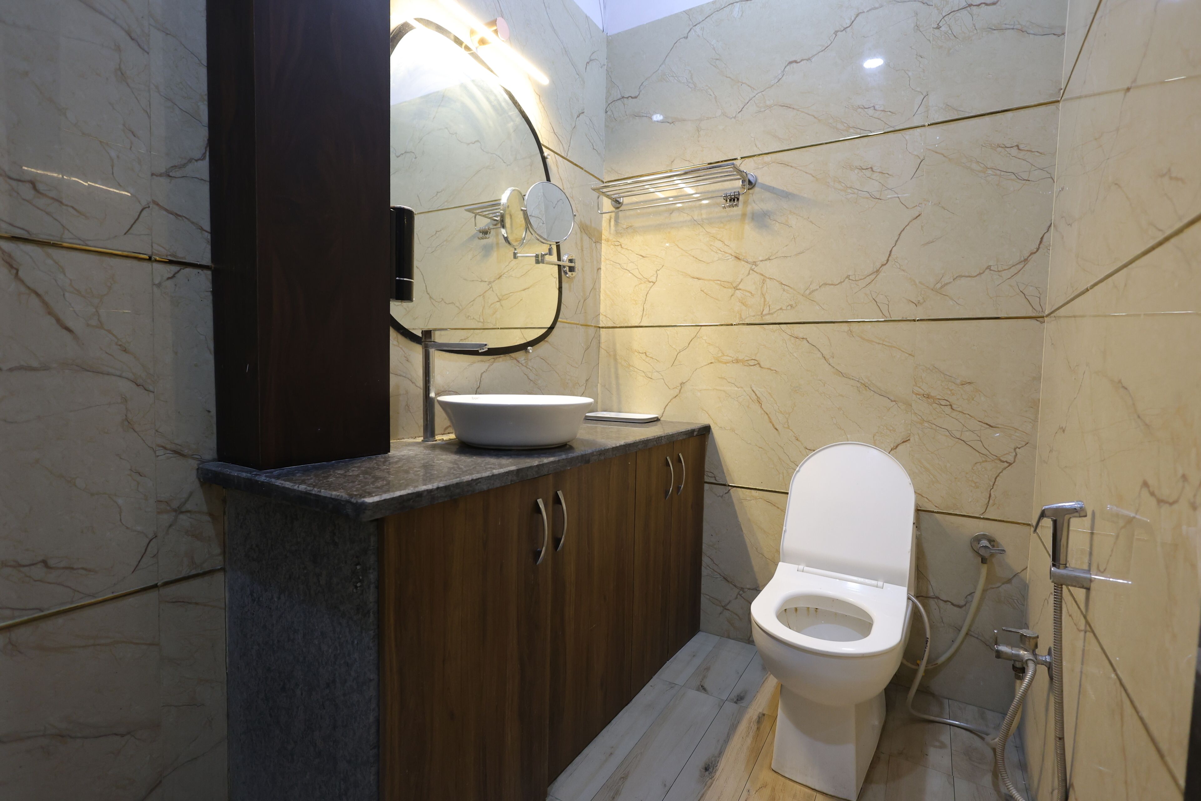 Een badkamer met een toilet, een wastafel, een spiegel en een douche.