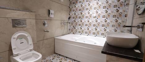 A bathroom with a toilet, bathtub, and sink.