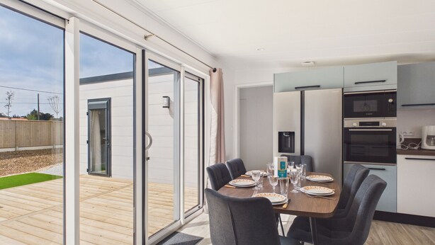 A modern kitchen with a dining area, large sliding glass doors, and a view of the outdoors. - Shared heated pool, accommodation for 6 (Saint-Gilles-Croix-de-Vie)