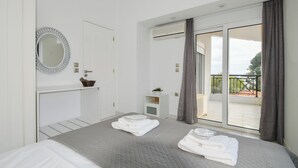 Et soveværelse med seng, et natbord, et spejl, et vindue og en balkon.