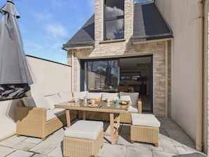 A patio with wicker furniture, a table, and an umbrella. - Charming house for 5 with garden and terrace (Sarzeau)