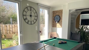 A pool table with a clock and dartboard in a room with a door leading outside. - Beach 300m away, house 8 adults and 2 children (La Plaine-sur-Mer)