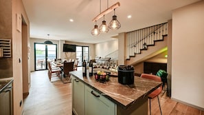 A modern kitchen with a marble island, wooden cabinets, and a dining area with a view. - Villa Ellen by Villas Guide (Bribir)