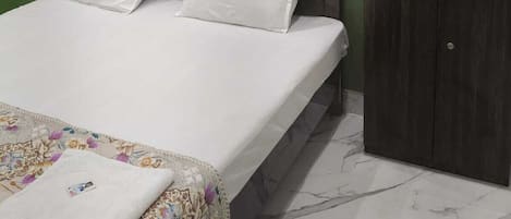 Ett rum med en säng, en garderob och en grön vägg.