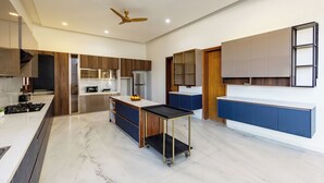 Una cocina moderna con una isla central, electrodomésticos integrados y un ventilador de techo.