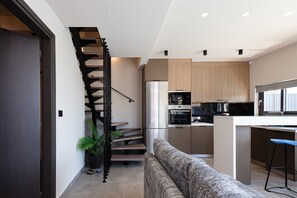 Una cocina moderna con horno empotrado, refrigerador y microondas.