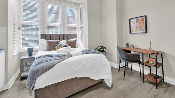 A bedroom with a bed, a desk, and a chair. - Sunny Serenity: Studio Living with a Breeze (London)