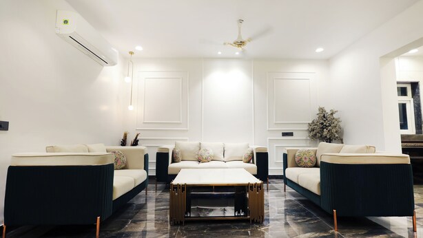 Un salon moderne avec un ensemble de canapés, une table basse et un ventilateur de plafond.