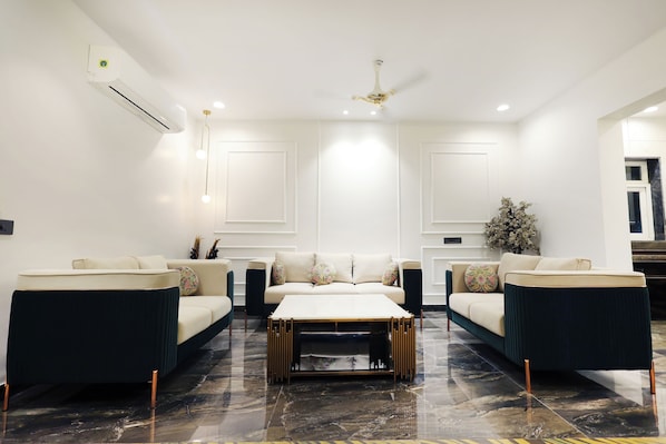 A modern living room with a sofa set, a coffee table, and a ceiling fan.