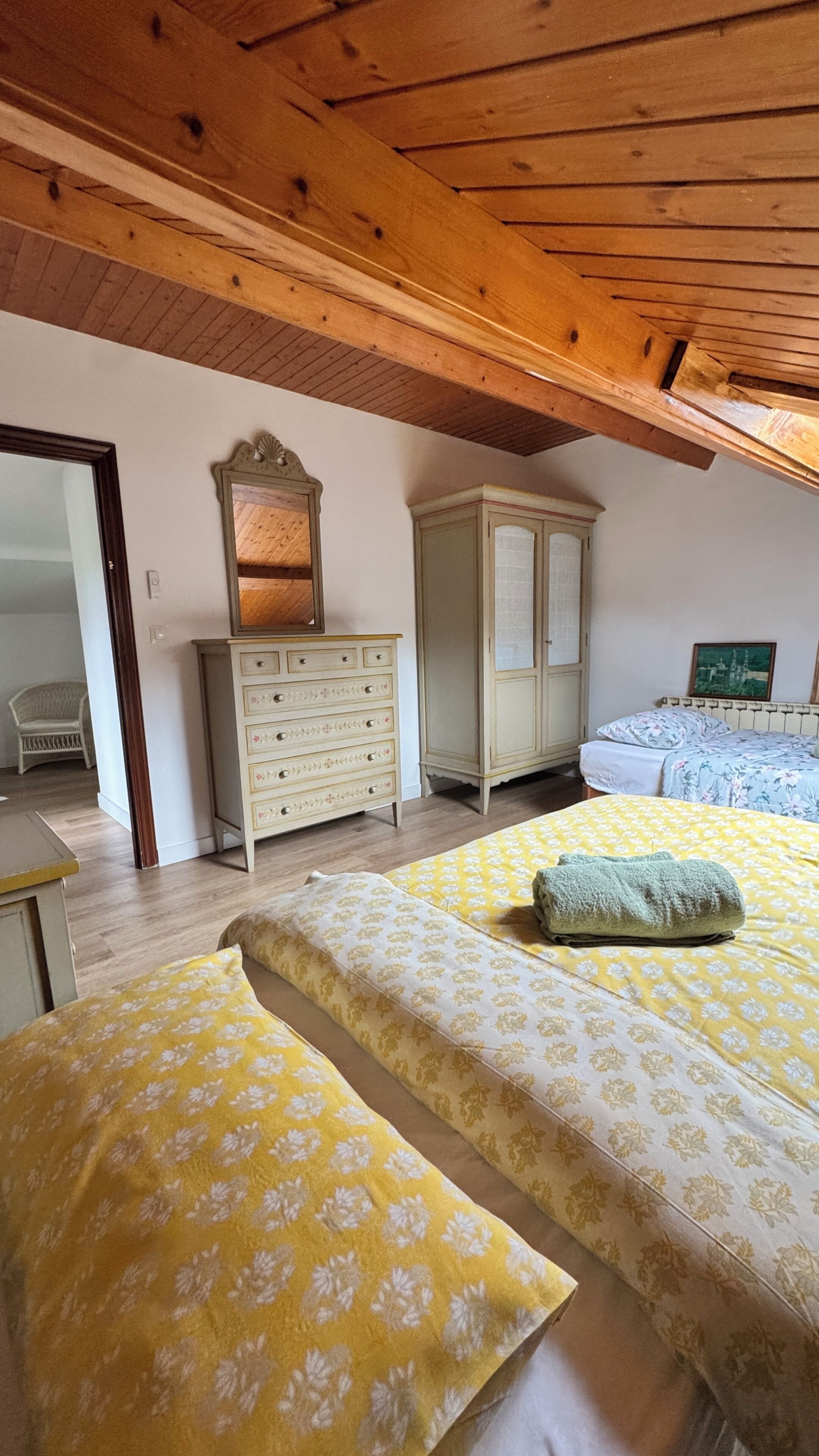 Un dormitorio con dos camas, un aparador, un armario y un espejo.