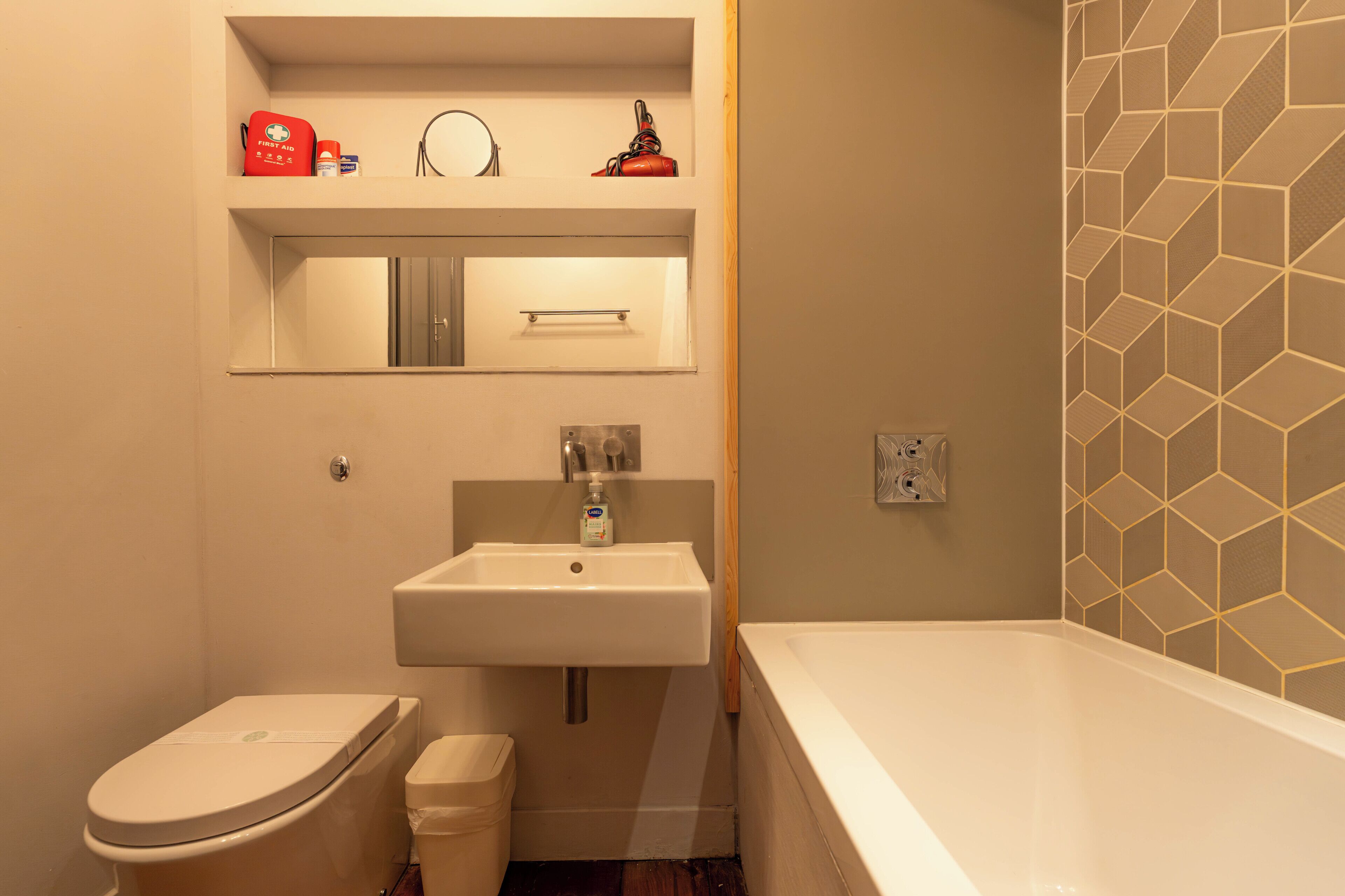 Une salle de bain avec des toilettes, un lavabo et une baignoire.