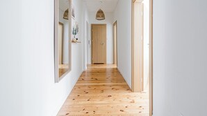 A long, narrow hallway with wooden flooring and white walls. - Imperial Apartments - Andersa (Sopot)