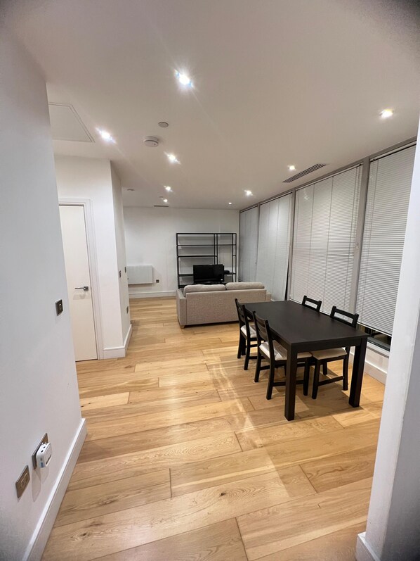 Un interior moderno con una mesa de comedor, sillas, un sofá y una televisión.