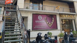 Un edificio a più piani che ospita diverse attività commerciali, tra cui un hotel, una gioielleria e un istituto scolastico.