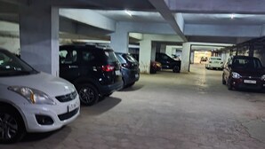 Un garage multipiano con diverse auto parcheggiate sotto un soffitto in cemento.