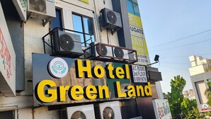 Un edificio con diversi cartelli, tra cui 'Hotel Green Land' e 'Educate Engineering Academy'.