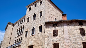 A historic stone building with multiple windows and a balcony. - Villa  Valle Lux by Villas Guide (Bale)