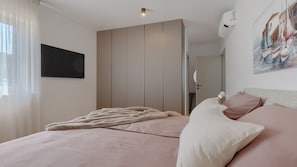 A bedroom with a bed, a TV, a painting, and an air conditioning unit. - Villa  Valle Lux by Villas Guide (Bale)