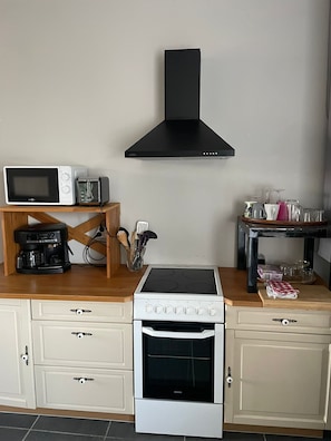 Une cuisine équipée d’une cuisinière, d’un four, d’un four à micro-ondes et d’un grille-pain.