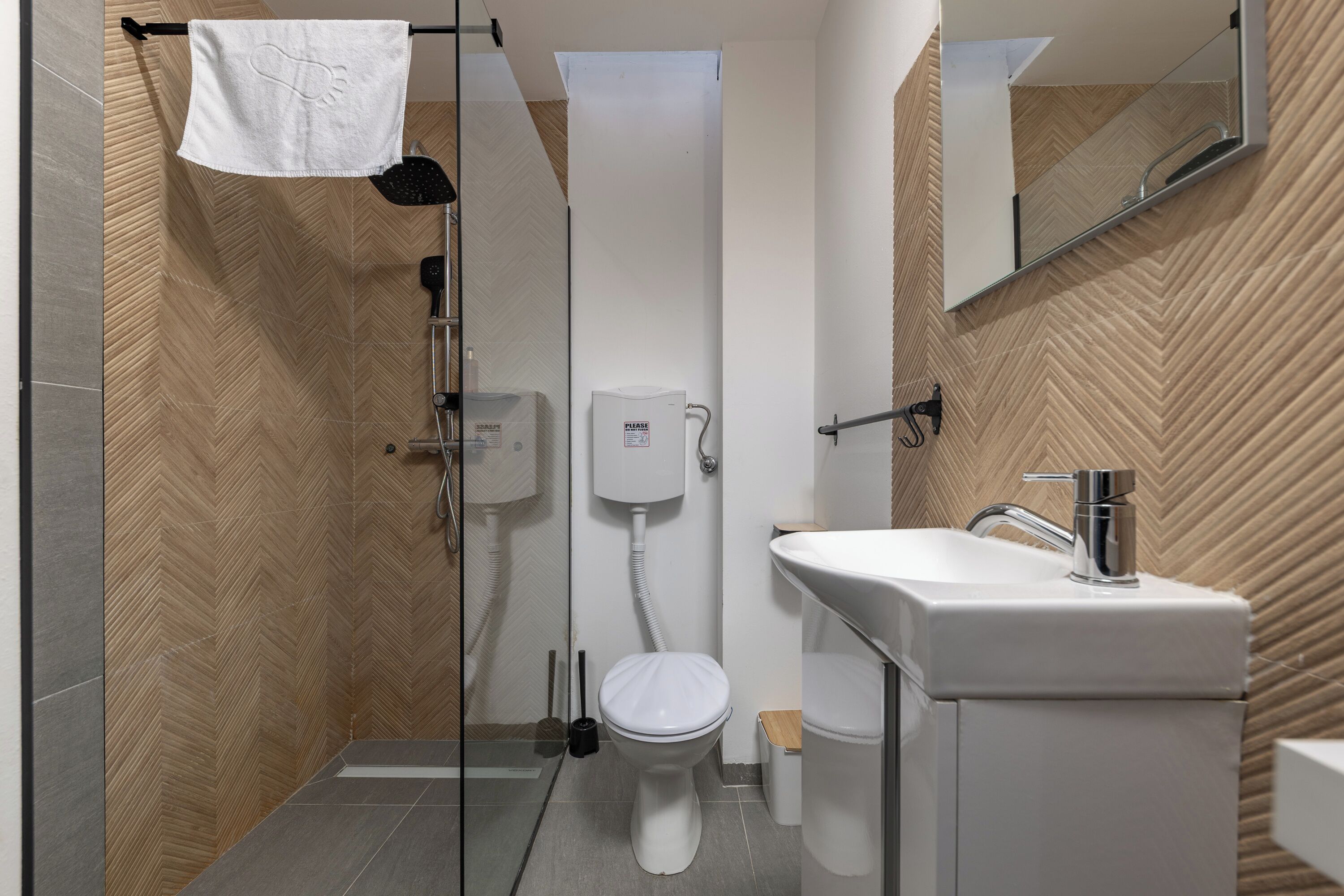 A modern bathroom with a shower, toilet, and sink.