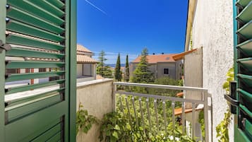 A balcony with a view of neighboring buildings and a clear blue sky.