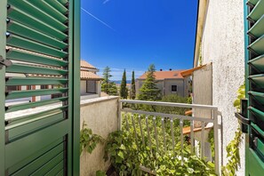 A balcony with a view of neighboring buildings and a clear blue sky. - Punta Debij Apartments (Punat)