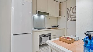 Una cocina moderna con refrigerador, horno, microondas y una caja de madera sobre la encimera.