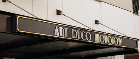 A marquee sign for 'ART DECO MOTION' with a classic design and a black and gold color scheme.