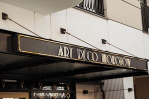 Une enseigne lumineuse pour « ART DECO MOTION », au design classique et aux couleurs noir et or.
