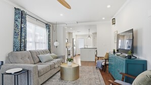 A modern living room with a sofa, coffee table, and a teal cabinet. - Midtown 3-bedroom house in vibrant Tulsa close to TU, Downtown, EXPO Square (Tulsa)