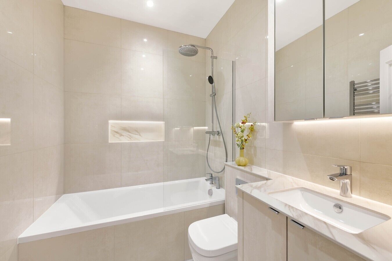 A modern bathroom with a bathtub, shower, and toilet.