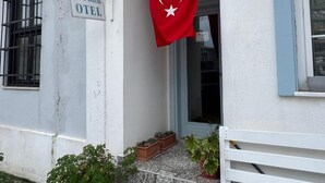 A building with a sign reading 'Hera Butik OTEL' and a Turkish flag. - HERA BUTİK OTEL (Bozcaada)