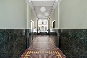 A hallway with marble walls and a patterned floor, leading to an elevator. - "3 Beds View Urban" + Metro Under the Duomo House 5 Minutes (Milano)