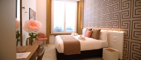 A hotel room with a bed, bedside table, chair, and a large window.