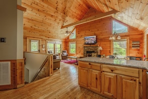 Ein Holzblockhaus mit Küche, Essbereich und Wohnzimmer.