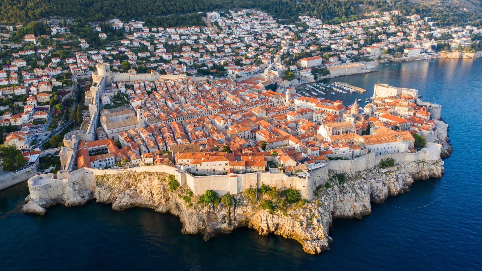 A coastal town with a fortified historic center, narrow streets, and a marina.