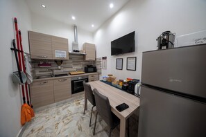 Eine moderne Küche mit Holzausstattung, integriertem Herd, Kühlschrank und einem Essbereich mit Stühlen.