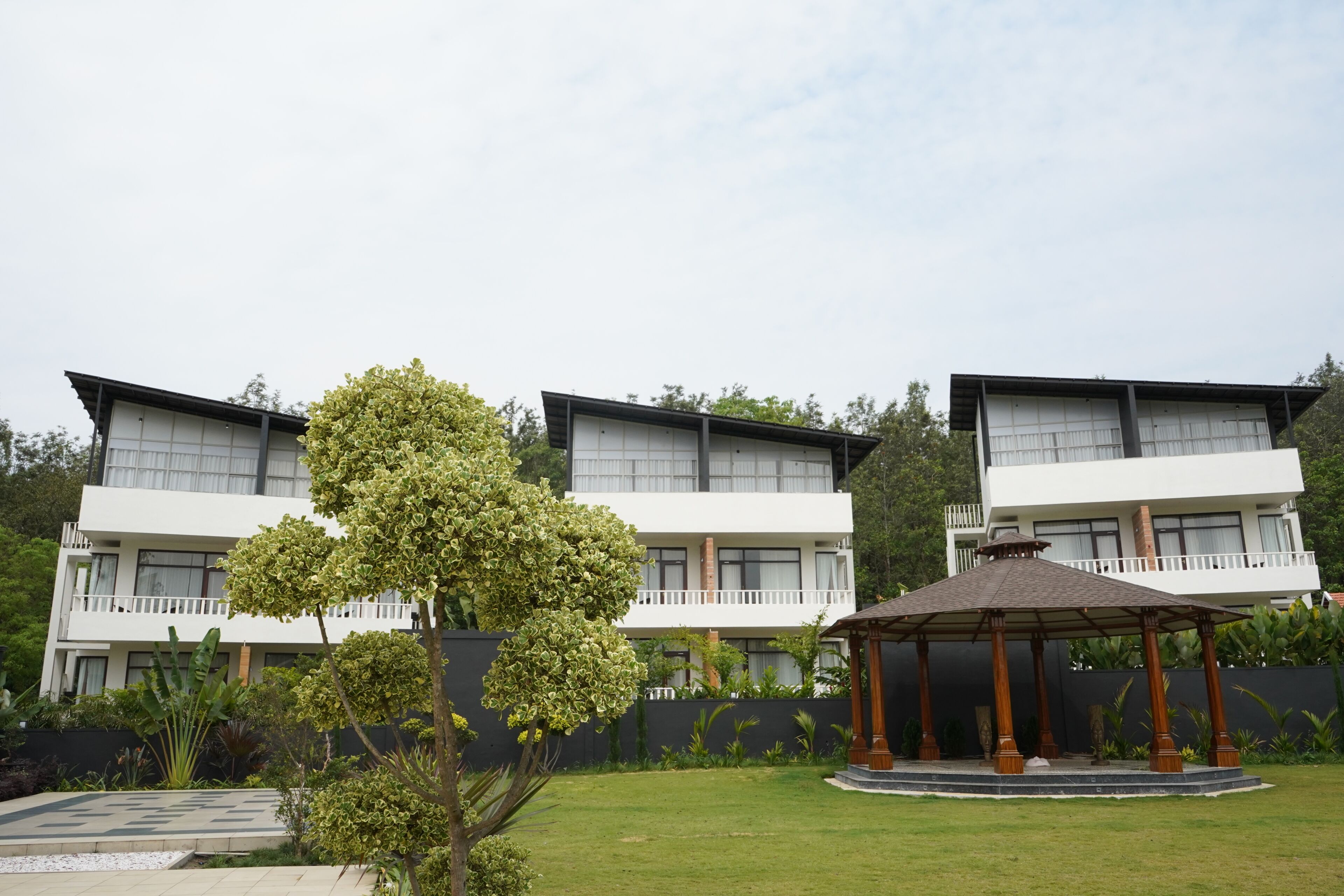 A modern building with a covered outdoor seating area and a well-maintained lawn.