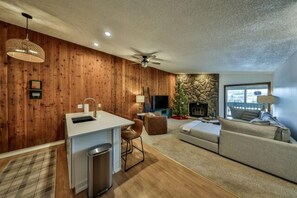 A compact living space with a kitchenette, a sofa, a television, and a fireplace. - 3rd floor 2 Bedroom 2 Bathroom condo with a wood fireplace (Winter Park)