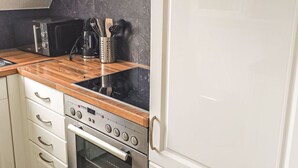 Eine Küche mit Einbauofen, Mikrowelle und Kaffeemaschine.