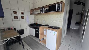 Une cuisine compacte équipée d’un four à micro-ondes, d’une machine à café et d’un petit réfrigérateur.