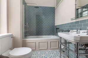Et badeværelse med brusebad, toilet og håndvask.