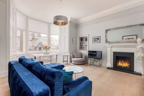 Ein Wohnzimmer mit Kamin, Fernseher und einer Couch.