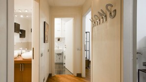 A hallway with wooden flooring, a sink, cabinets, and a door with the letters 'SAMS' on it. - "View Brera Penthouse" Private Jacuzzi + Duomo 5 Min (Milano)