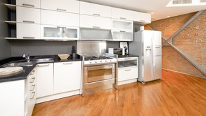A modern kitchen with white cabinetry, stainless steel appliances, and a wooden floor. - "View Brera Penthouse" Private Jacuzzi + Duomo 5 Min (Milano)
