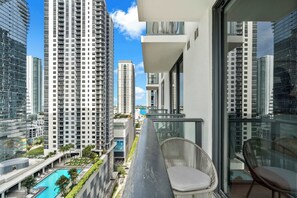 A high-rise building with a balcony overlooking a swimming pool and other buildings. - Stunning 1BR | Walk to PAMM & Frost Museum (Miami)