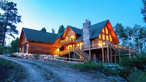 A log cabin with a stone chimney, wooden deck, and a dirt path leading to the entrance. - Lakeview Mountain Cabin with Wraparound Deck, Hot Tub & Wood Burning Fireplace. (Twin Lakes)