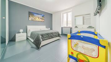 Ein Schlafzimmer mit Bett, Nachttisch, Lampe und einem Bild an der Wand.