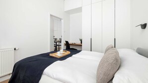 Une chambre moderne avec un lit, un bureau et une chaise au fond.